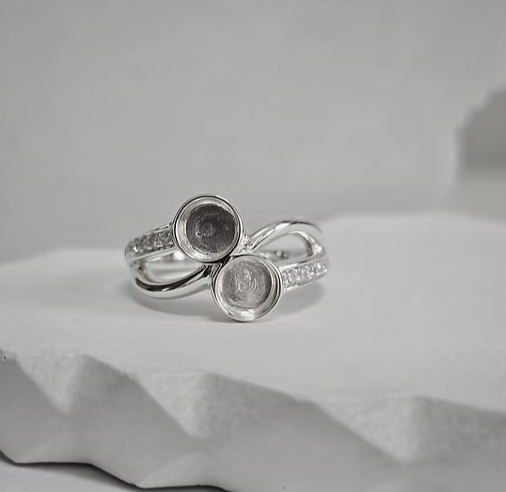925 sterling silver double round twist memorial ring on white surface showing twin 6mm bezels and CZ shoulders — top view