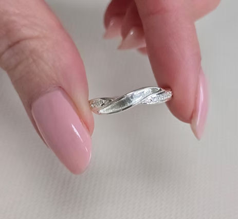 925 sterling silver single recess band memorial ring held between fingers showing true scale and CZ detail