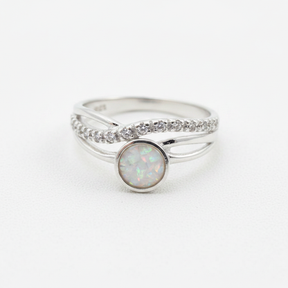 Silver 925 CZ crossover ring with white pearl opal resin in 5mm central setting on white background