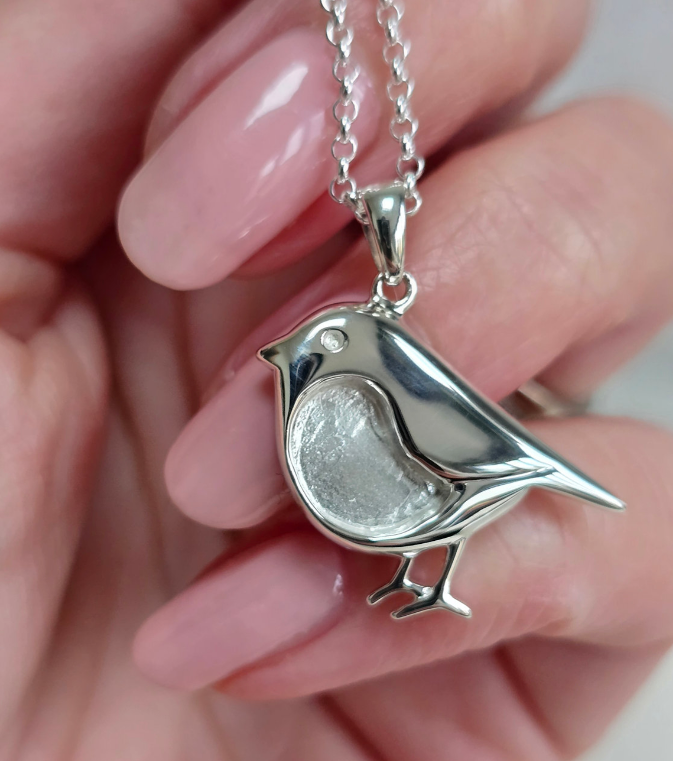 925 sterling silver robin memorial pendant — lifestyle shot held in hand showing true scale of robin pendant on belcher chain