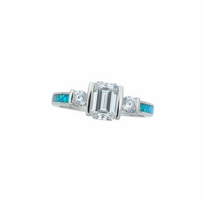 Emerald cut triple CZ bezel 925 silver ring with blue teal opal resin in side channels worn on finger white background