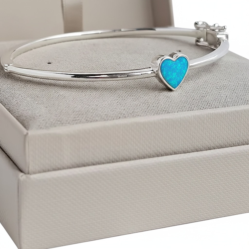 Bubble heart silver bangle with blue teal opal resin in heart bezel, white background