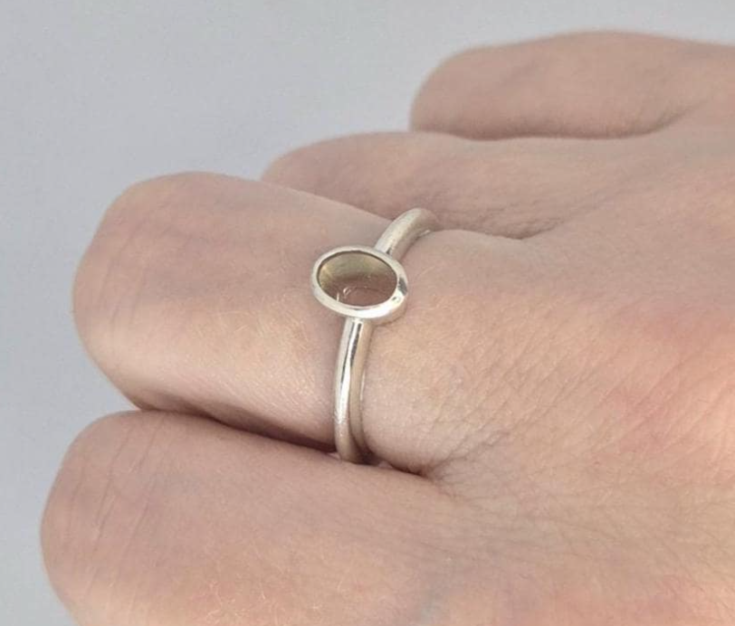 925 sterling silver 6x4mm oval bezel memorial ring worn on finger — showing oval bezel setting and slim round-wire band in true scale