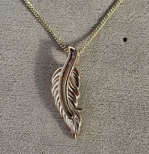 9ct yellow gold feather pendant on chain, angled view showing detailed feather barb texture and bail