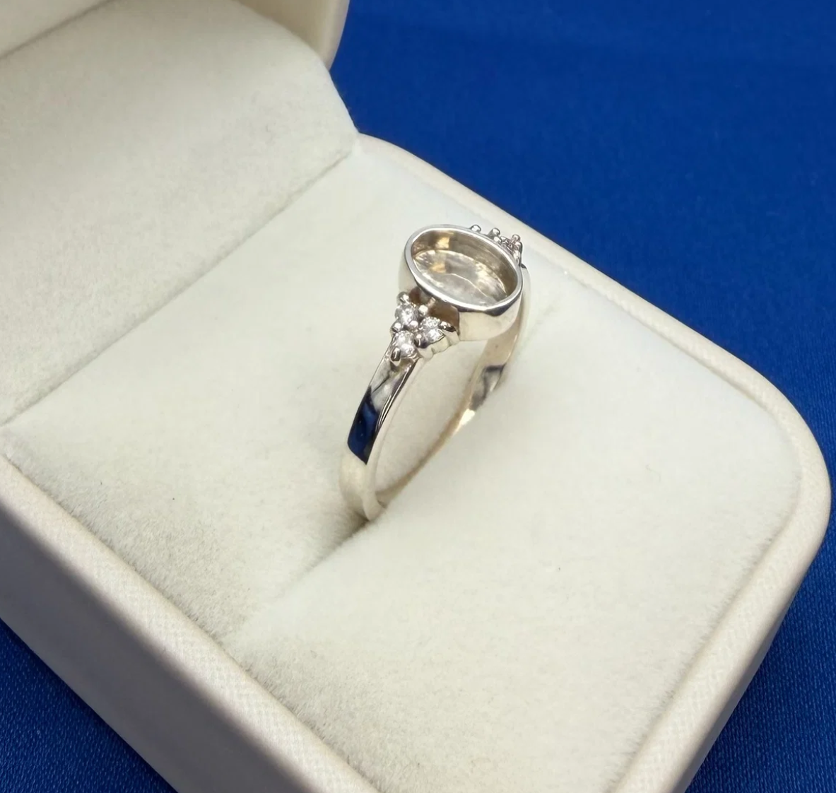 925 sterling silver oval triple CZ ring angled view showing oval bezel depth and CZ trio cluster detail on shoulder