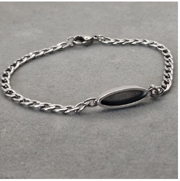 Stainless steel curb chain bracelet with oval bezel centrepiece filled with dark resin showing the finished look