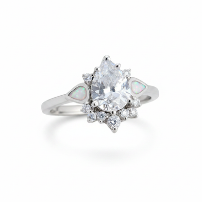 Silver 925 CZ dewdrop cluster ring with white pearl opal resin in tapered shoulder channels on white background