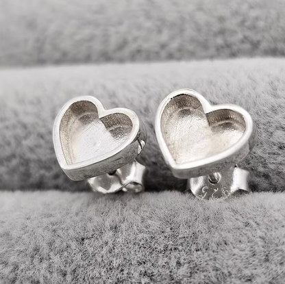 Silver 925 plain heart stud earrings showing butterfly backs on grey velvet