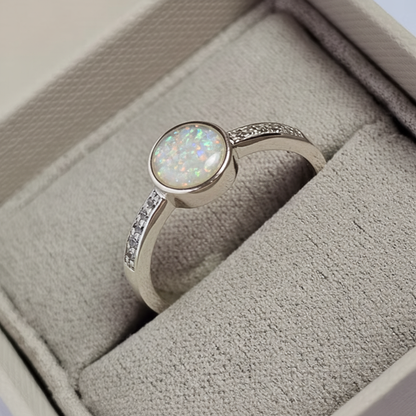 Silver 925 full shank CZ ring with white pearl opal resin in 6mm central setting on white background