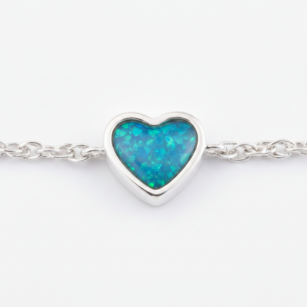 Close-up macro of heart bezel filled with blue teal opal resin showing silver channel border detail