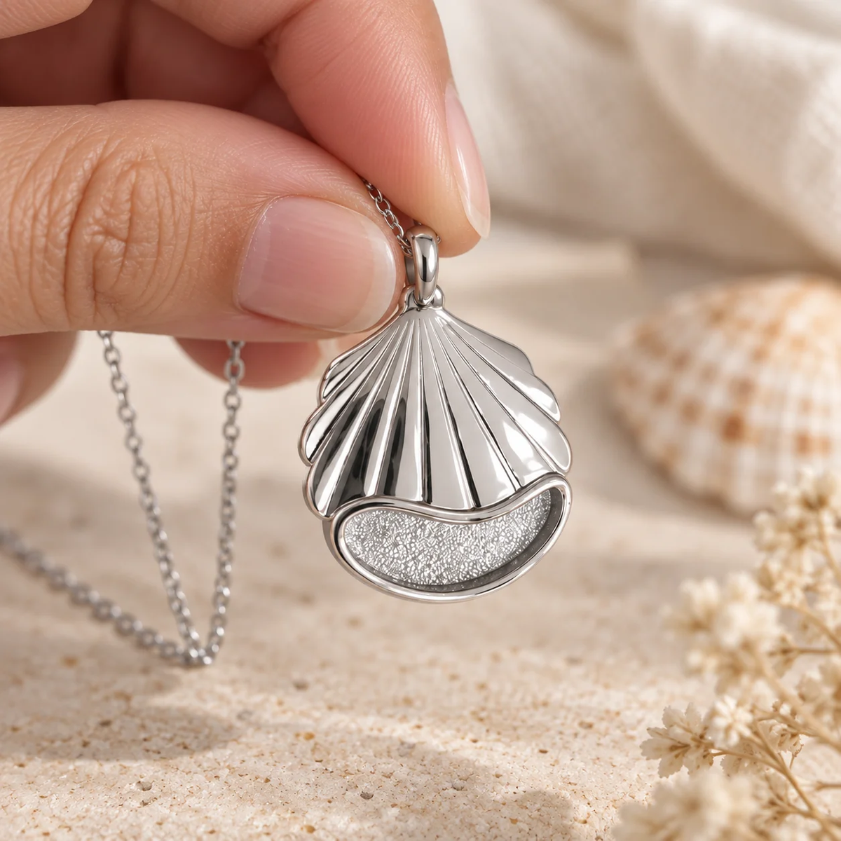 Seashell memorial pendant resting on sand