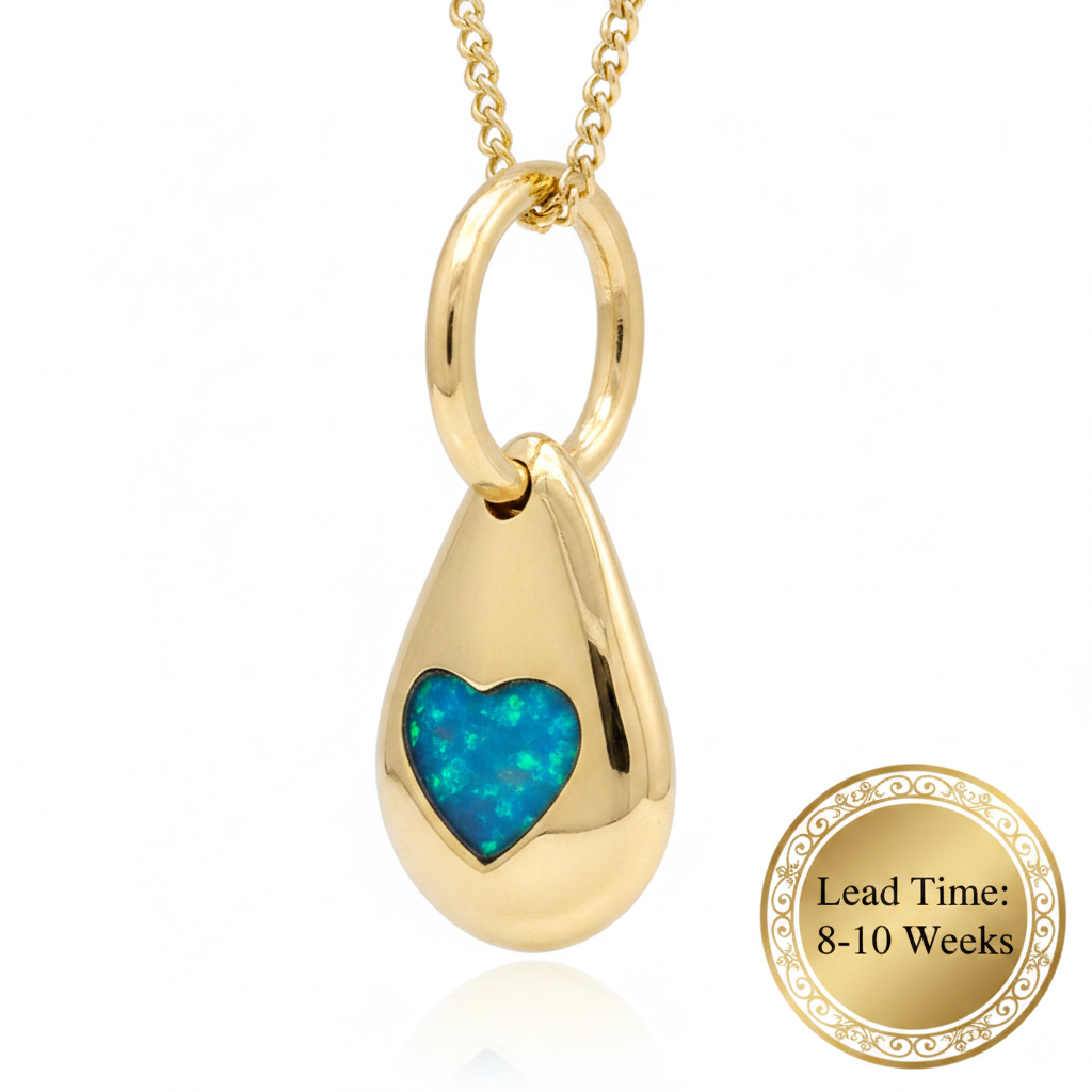 9ct gold solid 3D pebble heart pendant with blue teal opal resin heart bezel, white background, lead time 8-10 weeks sticker