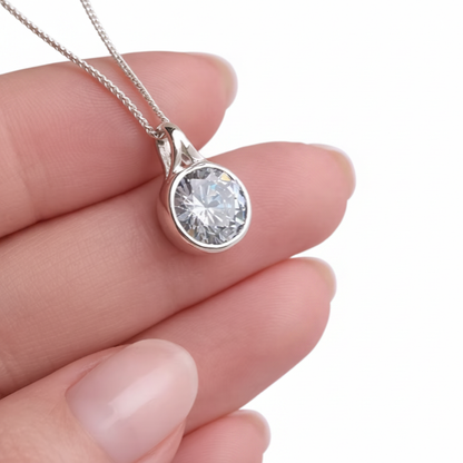 Round Secretly Set CZ 925 Silver Memorial Pendant held in hand — white background