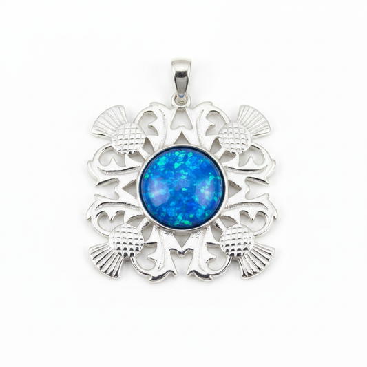 Silver 925 four-thistle filigree memorial pendant with blue opal flakes, white background