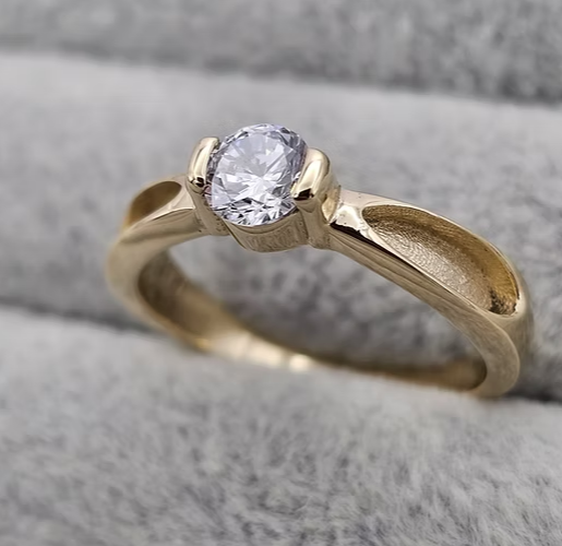 9ct yellow gold CZ solitaire ring with brilliant round cubic zirconia in half-bezel setting and crossover twist shank, angled view