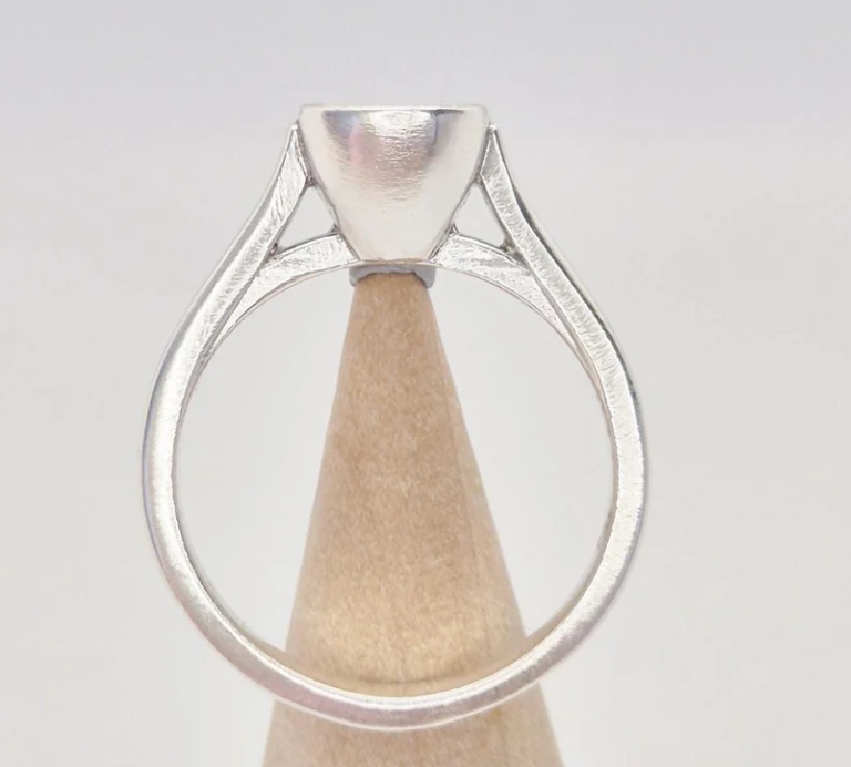 925 sterling silver 6mm cushion bezel cathedral memorial ring — back view on wooden cone showing open triangular cathedral shank cutouts