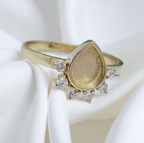 9ct yellow gold CZ raindrop ring angled view on white silk fabric