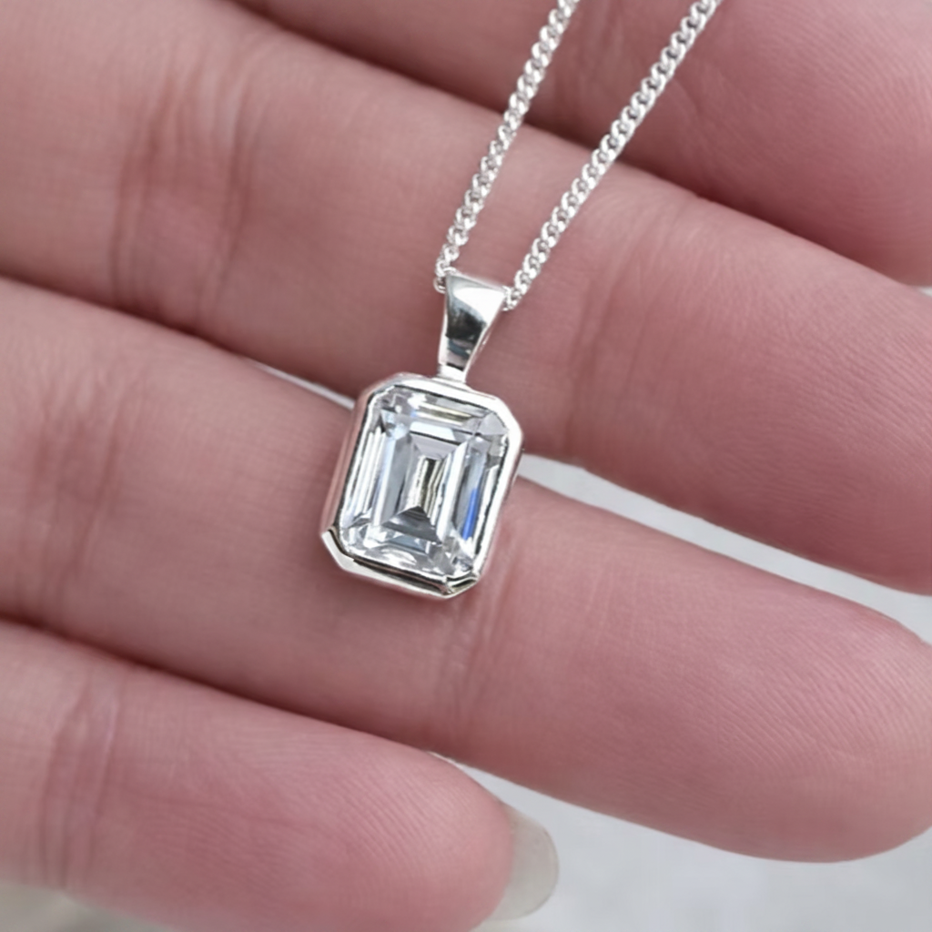 Emerald Cut Secretly Set CZ 925 Silver Memorial Pendant held in hand — white background