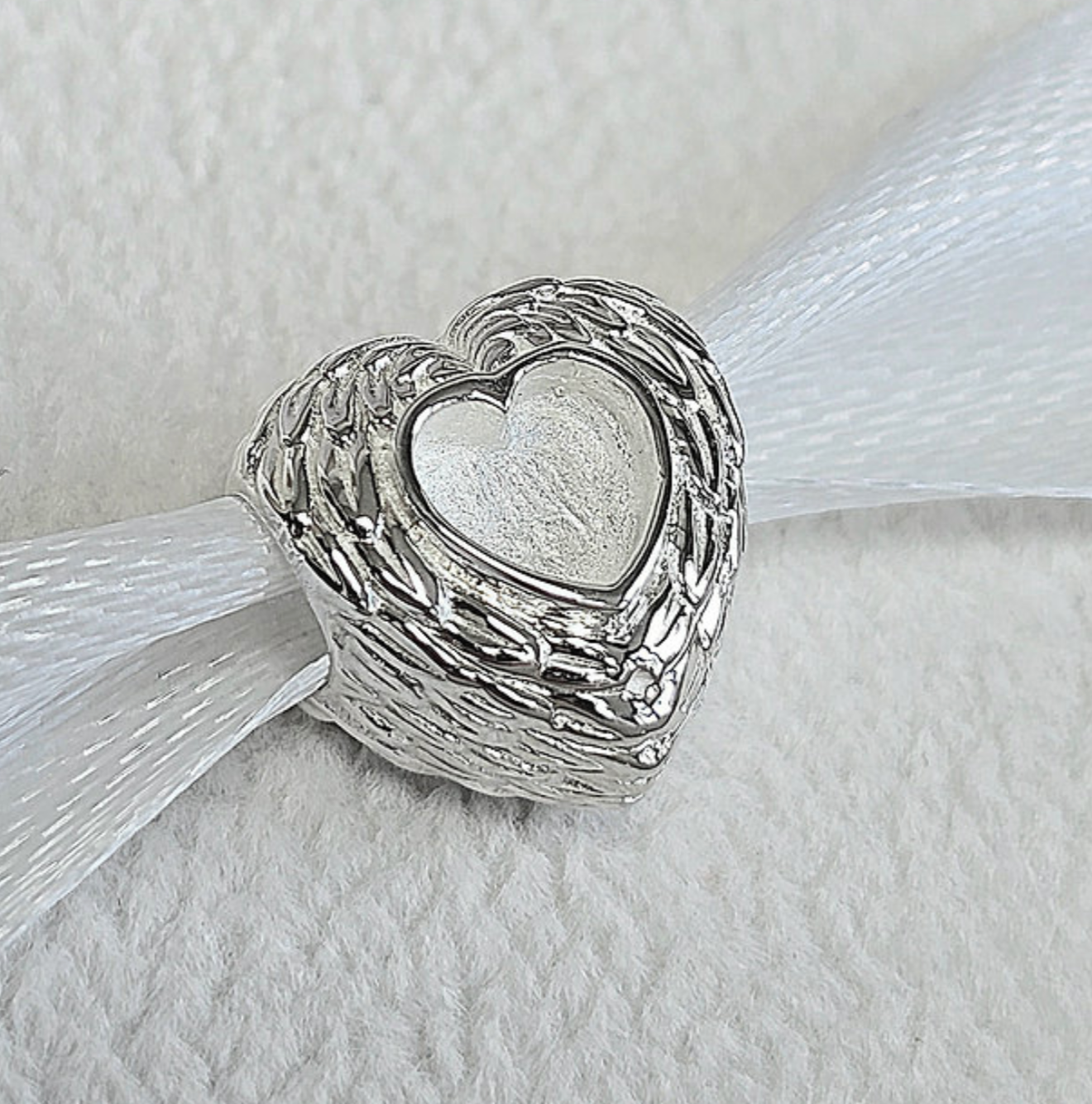 925 sterling silver feather heart memorial charm — front view showing full angel wing feather texture and heart resin recess
