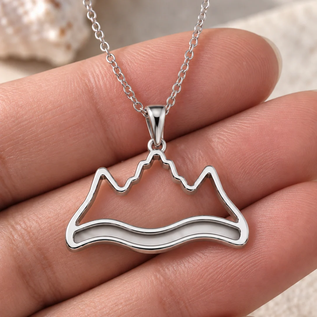 Mountain and river memorial pendant in stainless steel held in hand