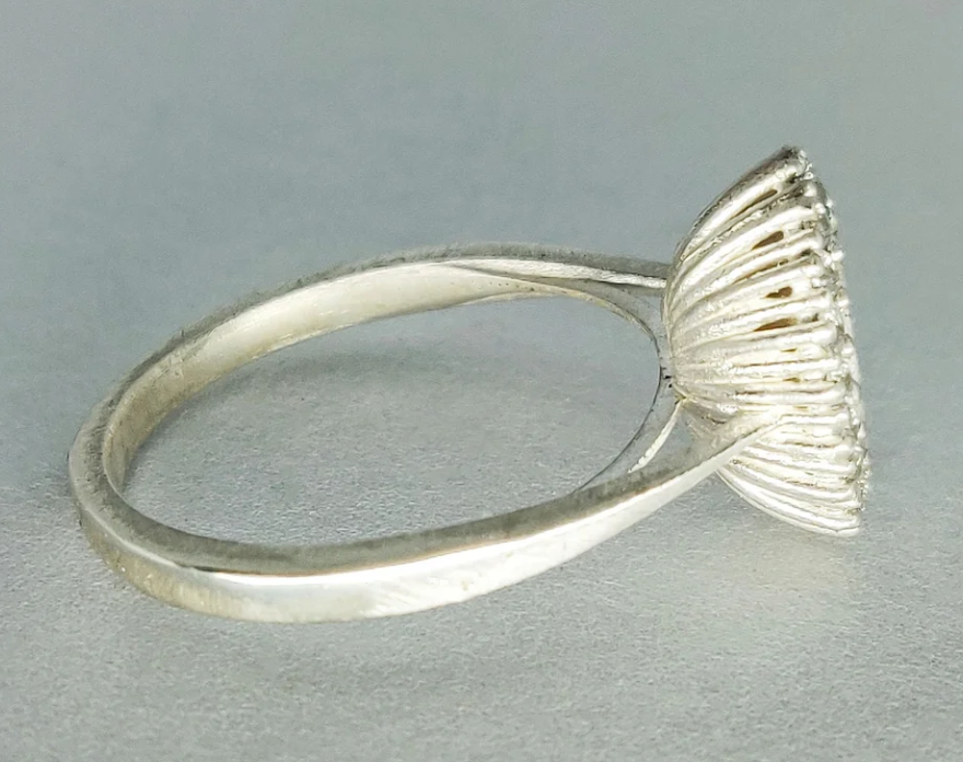 925 sterling silver oval CZ halo memorial ring — side profile on grey surface showing slim cathedral shank height and ribbed gallery detail