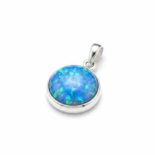 Plain edge silver round memorial pendant with blue opal flakes inclusion, white background