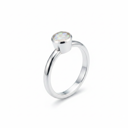 Handcrafted sterling silver rubover memorial ring with white pearl opal and mica shimmer in flat resin setting on white background
