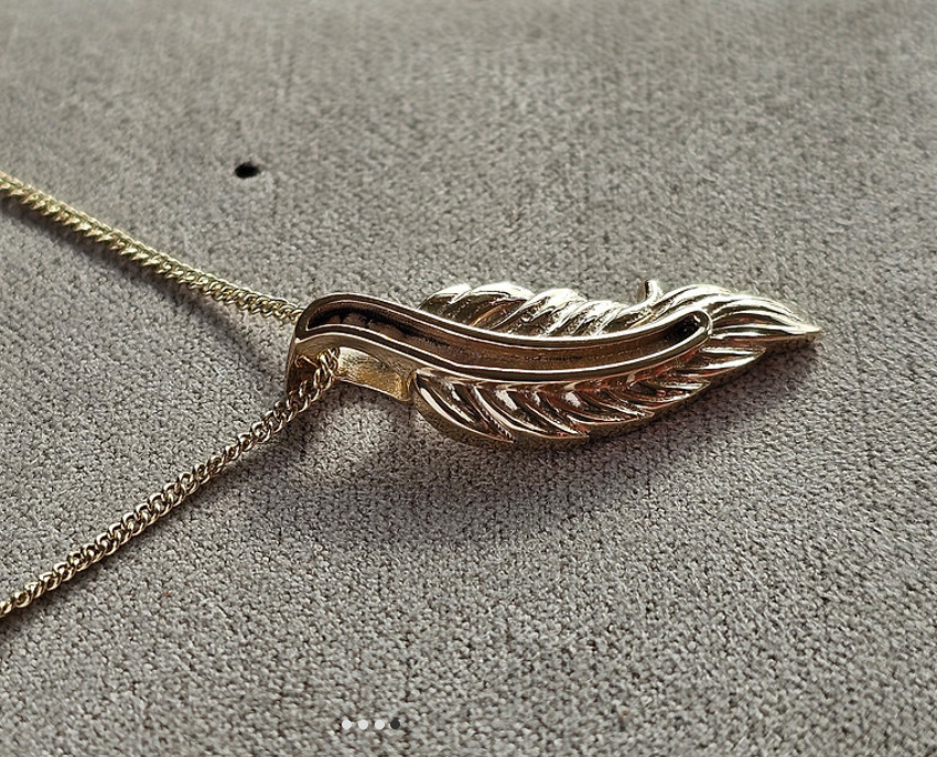 9ct rose gold feather pendant on chain, side angle view showing 3D depth and intricate feather detail