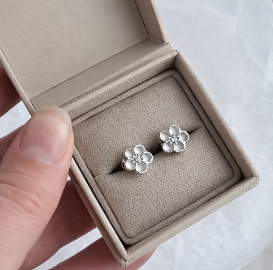 Forget-Me-Not 925 silver stud earrings held in hand showing true scale