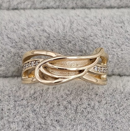 9ct yellow gold angel wing CZ ring top view on grey velvet showing flowing band design