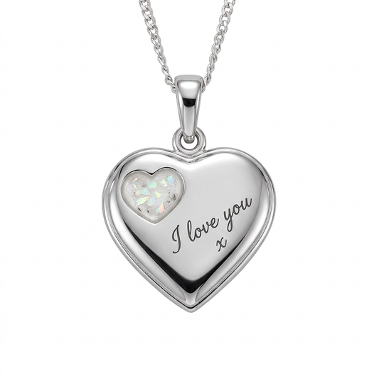 Illustrative engraved silver heart pendant with pearl white opal flakes and ashes in the small heart recess