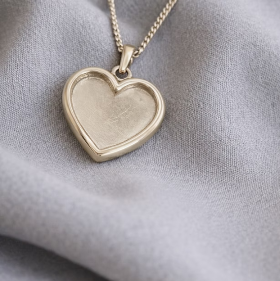 9ct yellow gold thick trim heart pendant on gold chain on grey silk fabric