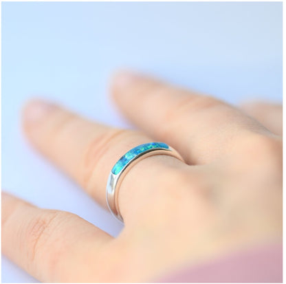 Ladies silver channel ring with opals and ashes, sparkling in natural light, perfect for a meaningful keepsake.